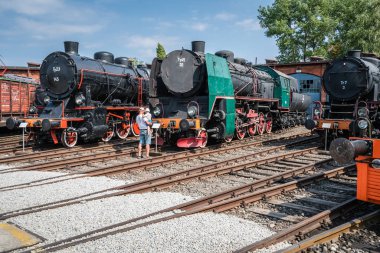 Jaworzyna Slaska, Polonya - Ağustos 2018: Adam eski terkedilmiş retro görünümlü bir çocuk ile tren lokomotifler ve Sanayi Müzesi ve demiryolu Silezya'da deposunda yan pistlerde küçük yük arabalar