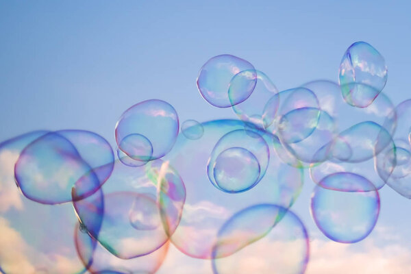 Giant soap bubbles floating high in the air with the blue sky in the background
