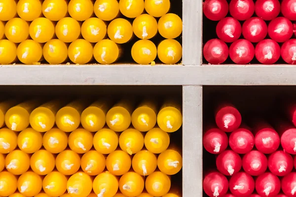 商店货架上的红色和黄色石蜡棒蜡烛安排 — 图库照片
