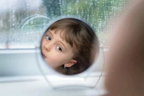 Menina Branca Bonito Olhando Para Pequeno Espelho Redondo Enquanto Penteia — Fotografia de Stock