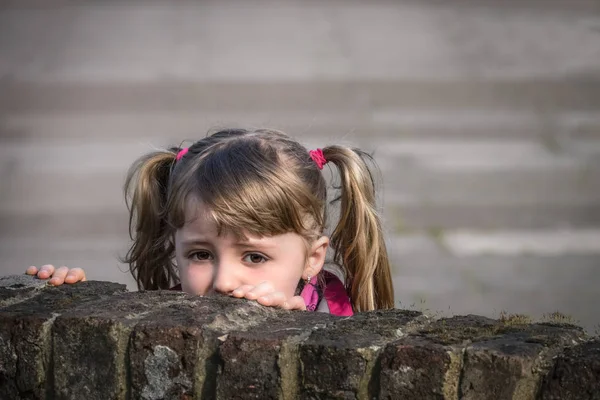 Cute Little Caucasian Girl Looking Scared Hiding Brick Wall — Stock Photo, Image