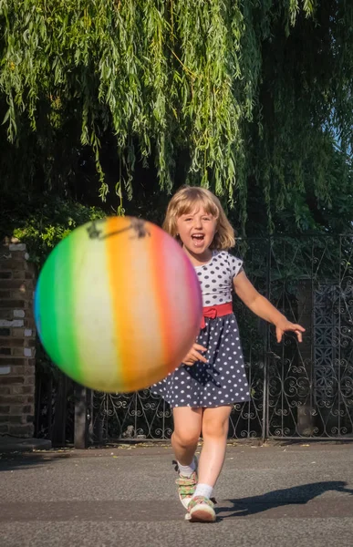 Menina Correndo Atrás Bola Elástica Macia Colorida Enquanto Joga Pavimento — Fotografia de Stock