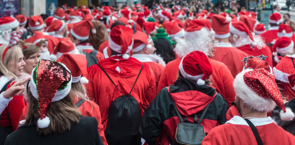Лондон, Великобритания - Декабрь 2018: Группа людей, одетых в костюмы Санты и принимающих участие в тематическом мероприятии SantaCon
