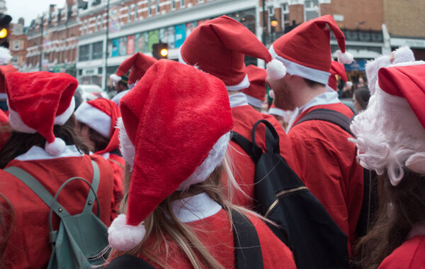 London, UK - December 2018 : Group of people dressed in santa outfits and taking part in a themed SantaCon event