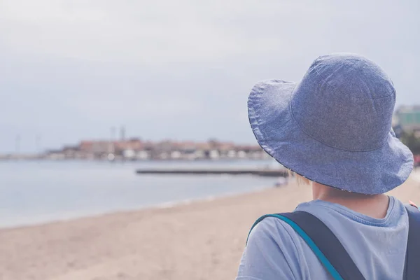 在黑山布德瓦的避暑胜地度假小镇 持蓝色帽子走在阳光明媚的海滨长廊上的白人妇女 — 图库照片