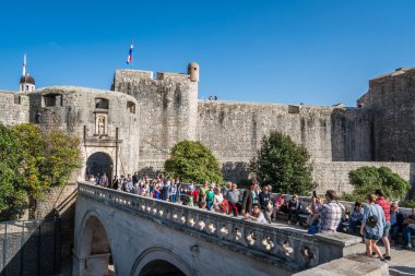Dubrovnik, Hırvatistan - Nisan 2018: Kalabalığın büyük kalın taş kapılar Dubrovnik'in tarihi kent için önde gelen hendek köprüyü geçtikten