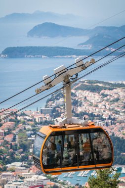 Dubrovnik, Hırvatistan - Nisan 2018: Dubrovnik teleferik, insan üst kısmında Mount Srd tarihi eski şehir duvarlarının üzerinde popüler bir turistik