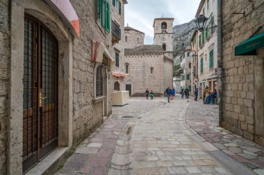 Kotor, Karadağ - Nisan 2018: Kotor Old Town Aziz Nikolaos Kilisesi çan kulesinde önünde kare üzerinde yürüyen turist