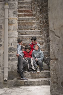 Kotor, Karadağ - Nisan 2018: merdivenlerde oturan ve bir küçük elektronik cihaz, Kotor Old Town oyun Karadağ çocuk