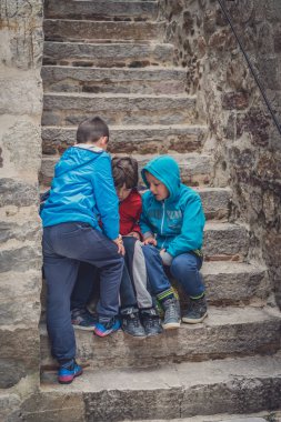 Kotor, Karadağ - Nisan 2018: merdivenlerde oturan ve bir küçük elektronik cihaz, Kotor Old Town oyun Karadağ çocuk