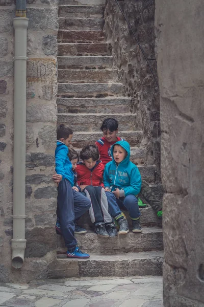 Kotor, Karadağ - Nisan 2018: merdivenlerde oturan ve bir küçük elektronik cihaz, Kotor Old Town oyun Karadağ çocuk