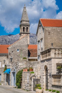 Perast, Karadağ - Nisan 2018: Eski kırmızı kiremitli evleri ve Aziz Nikola Kilisesi kule Perast, Kotor liman içinde