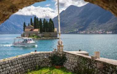 Perast, Montenegro - April 2018 : View of the small Church on San George`s island in Kotor bay as seen from the walls of Our Lady of the Rocks chapel clipart