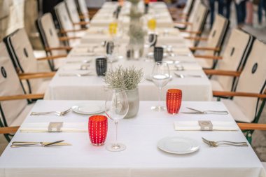 Şarap bardakları, tabaklar ve çatal bıçaklar restorandaki tören başlamadan önce masaya kondu.