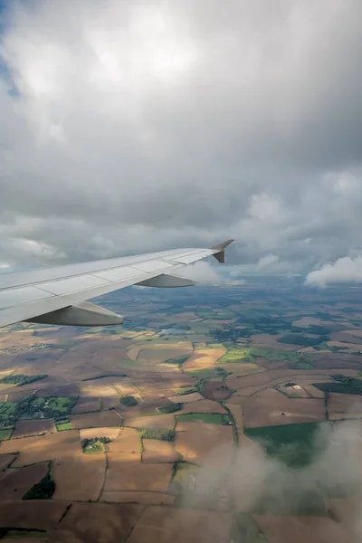 Airplane flying above the english countryside — Stock Photo, Image