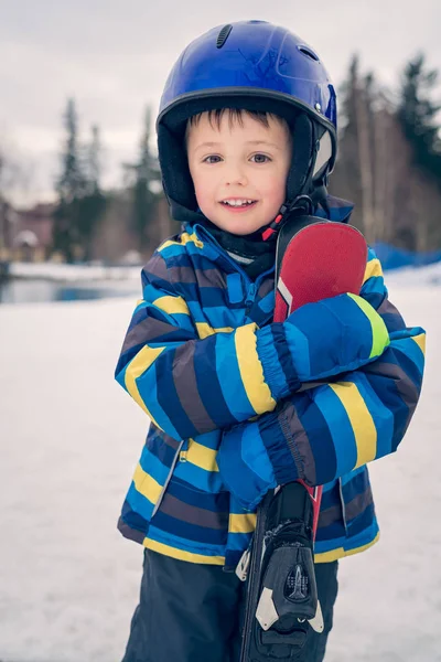 Kleine jongen houdt zijn ski's in de winter — Stockfoto