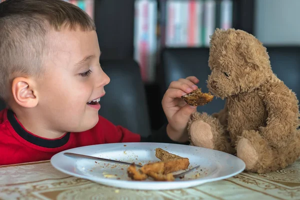 Kleiner Junge frühstückt mit seinem Teddybär — Stockfoto
