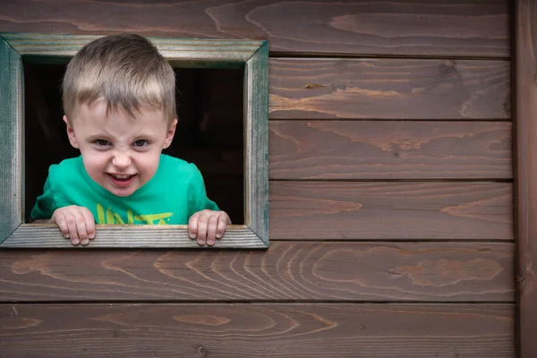 Cheeky boy looking through the window — Stock Photo, Image