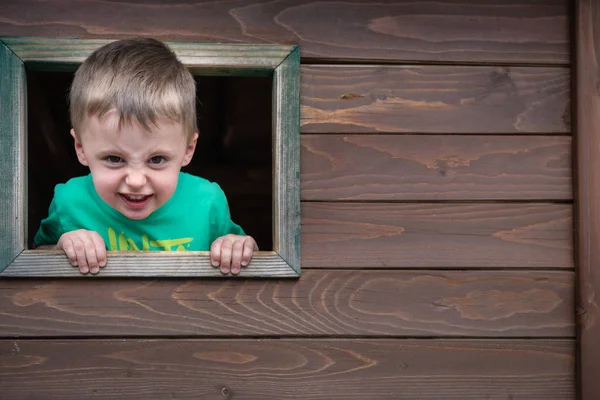 Cheeky boy looking through the window Royalty Free Stock Images