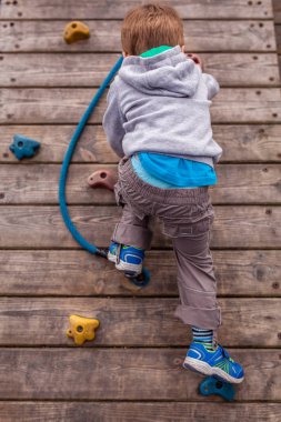 Yapay kaya duvarına tırmanan küçük çocuk