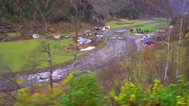 Norveç'in bir parçası olarak Flam ve Myrdal arasında uzanan doğal Flamsbana tren hattından görüldüğü gibi dağ vadisi ve köy Flam görünümü, Norveç