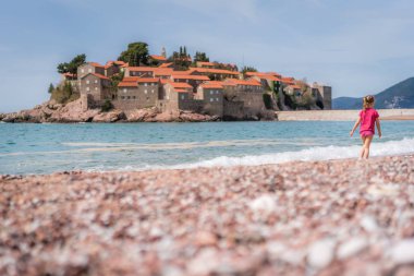 Sveti Stefan sahilde yürüyen kız