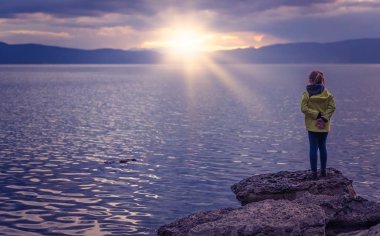 Göl kıyısında duran küçük kız