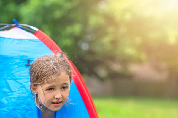 Menina olhando através de uma tenda — Fotografia de Stock