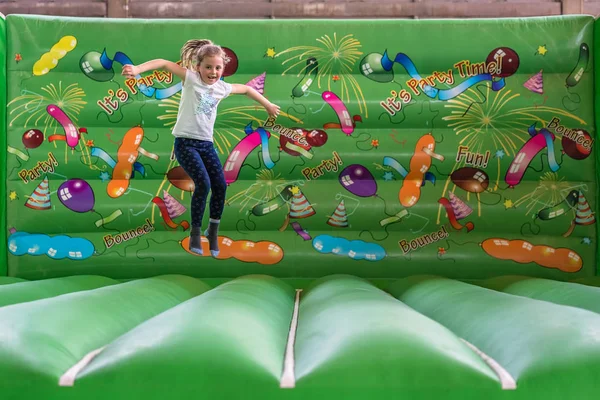 Menina pulando dentro do castelo bouncy — Fotografia de Stock