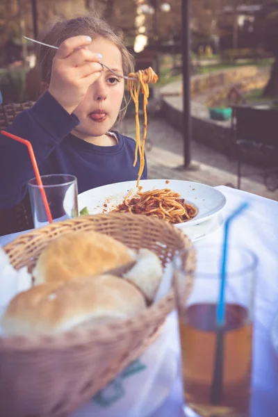 Spagetti yiyen sevimli küçük bir kızın portresi — Stok fotoğraf