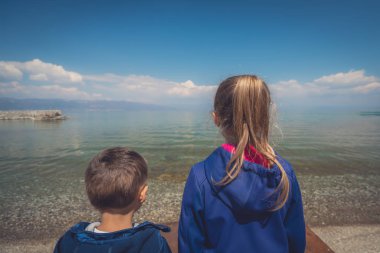 Göl kıyısında duran küçük çocuklar