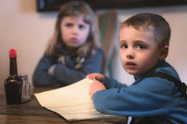 Çocuklar restoranda masada oturuyorlar. 