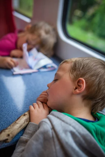 Crianças cansadas dormindo em um trem — Fotografia de Stock