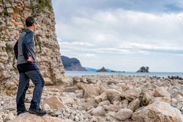 Человек, стоящий на скалистом побережье Черногории — стоковое фото