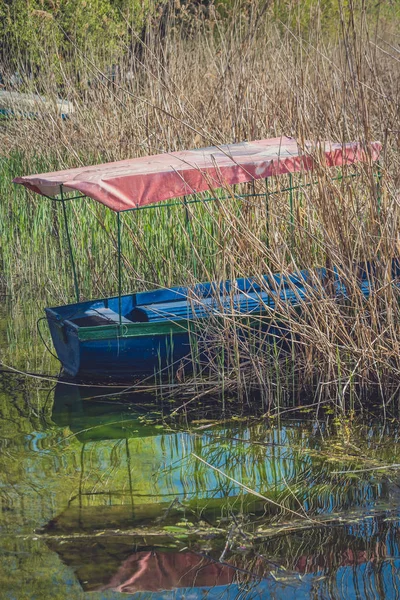 Маленькая лодка, спрятанная и пришвартованая среди потоков — стоковое фото
