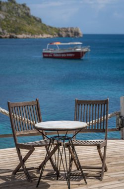 Bir güverte platformu üzerinde ahşap sandalye ve masa