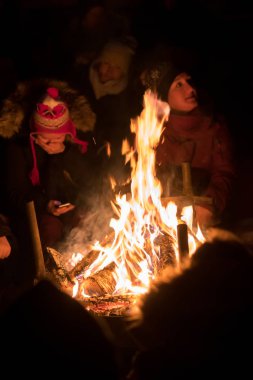 İnsanlar ateşin yanında ısınıyor.