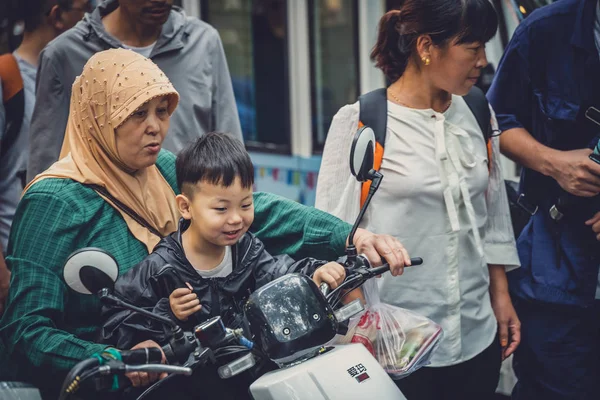 Мусульманська жінка з сином на скутері — стокове фото