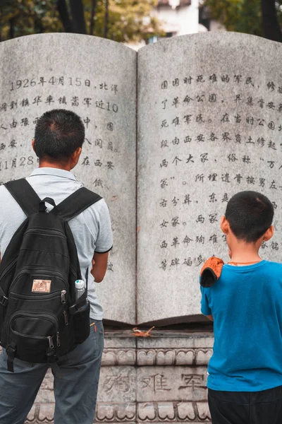 Pai e filho lendo de um livro de pedra — Fotografia de Stock