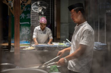 Çinli şef sıcak yemek hazırlıyor