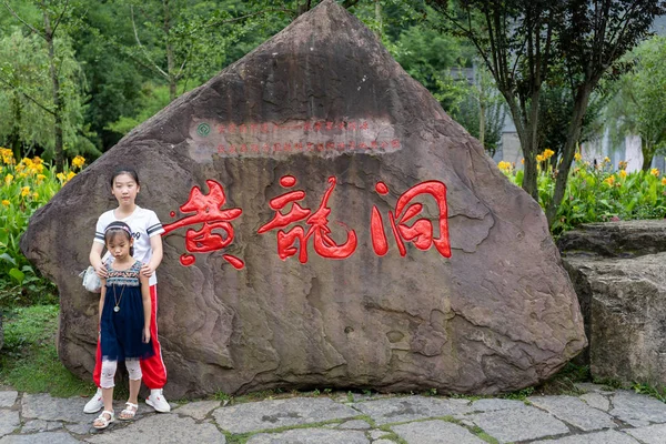 Kinder vor Stein mit chinesischen Schriftzeichen — Stockfoto