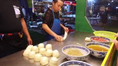 Xian, Çin - Ağustos 2019: Müslüman Mahallesi 'ndeki küçük bir yerel pastanede kıymalı et yapan adam