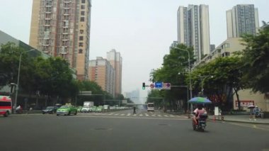 Chengdu, Çin - Temmuz 2019: Geniş sokak şeritlerinde yeşil taksiler, arabalar ve otobüsler Chengdu şehrinin yüksek katlı banliyölerinden geçiyor yaz sabahı, Sichuan Eyaleti, Orta Çin