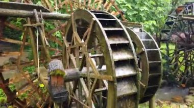 Huanglong Sarı Ejder Mağarası manzaralı, Zhangjiajie, Hunan, Çin 'de eski değirmen ahşap su çarkları işliyor ve dönüyor.