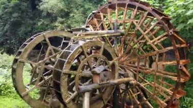Huanglong Sarı Ejder Mağarası manzaralı, Zhangjiajie, Hunan, Çin 'de eski değirmen ahşap su çarkları işliyor ve dönüyor.