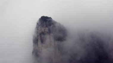 Tianmen dağlarının devasa dikey taş sütunu alçak sabah bulutlarıyla kaplanmış, Zhangjiajie Ulusal Parkı, Hunan Eyaleti, Çin