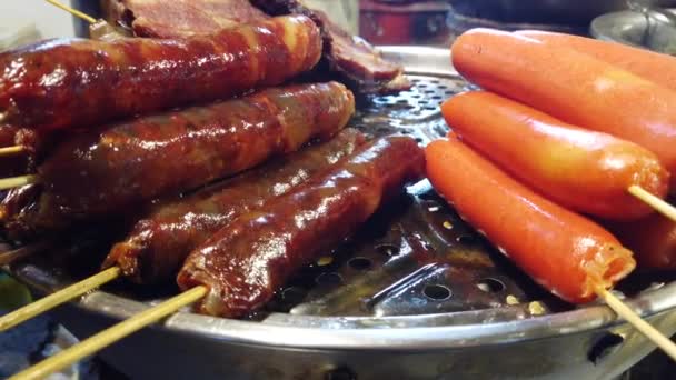在中国街头食品室内市场上 在自制的烤架上烤着褐色美味的猪肉和牛肉香肠 — 图库视频影像