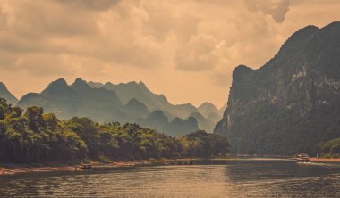 Yangshuo yakınlarındaki görkemli Li nehrinin nehir kıyısında sersemletici karst dağ manzarası, sıcak bir yaz günü, Çin