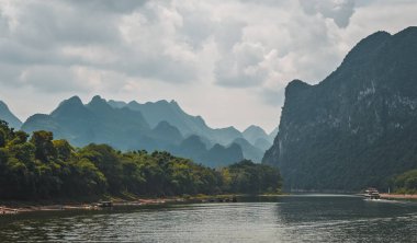Yangshuo yakınlarındaki görkemli Li nehrinin nehir kıyısında sersemletici karst dağ manzarası, sıcak bir yaz günü, Çin