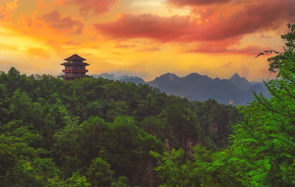Tianzi dağ sırasının baş döndürücü kaya sütunlarına bakan bir dağın tepesinde geleneksel Çin mimari tapınağı binası Avatar dağları doğa parkı, Zhangjiajie, Çin